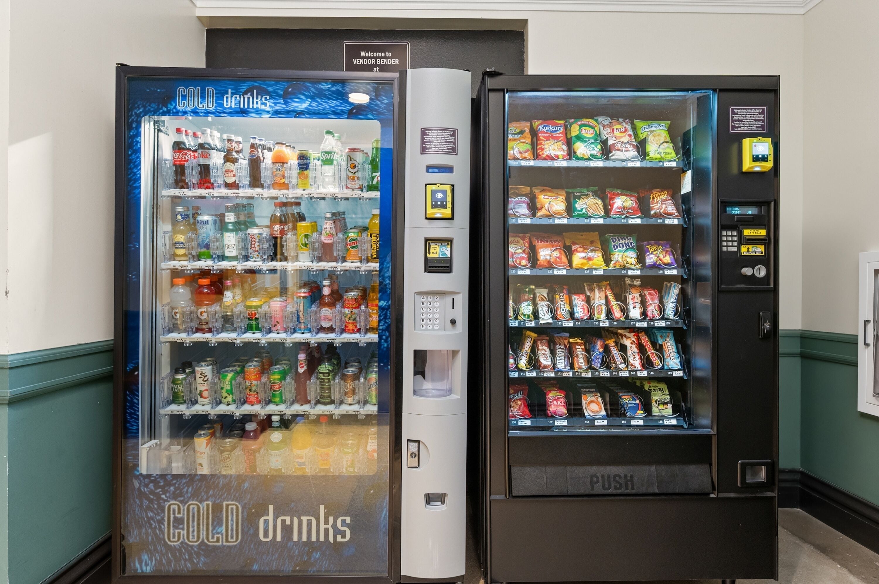 Due distributori automatici, uno con l'indicazione 'COLD drinks' e l'altro 'PUSH', contenenti diverse bevande e snack.