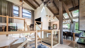 A modern interior with a wooden staircase, a dining area, and large windows. - JATOBA - Chalet with a jacuzzi and cinema corner (Chamonix-Mont-Blanc)
