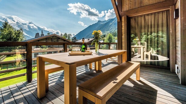 A wooden deck with a table and benches, overlooking a mountain landscape. - JATOBA - Chalet with a jacuzzi and cinema corner (Chamonix-Mont-Blanc)