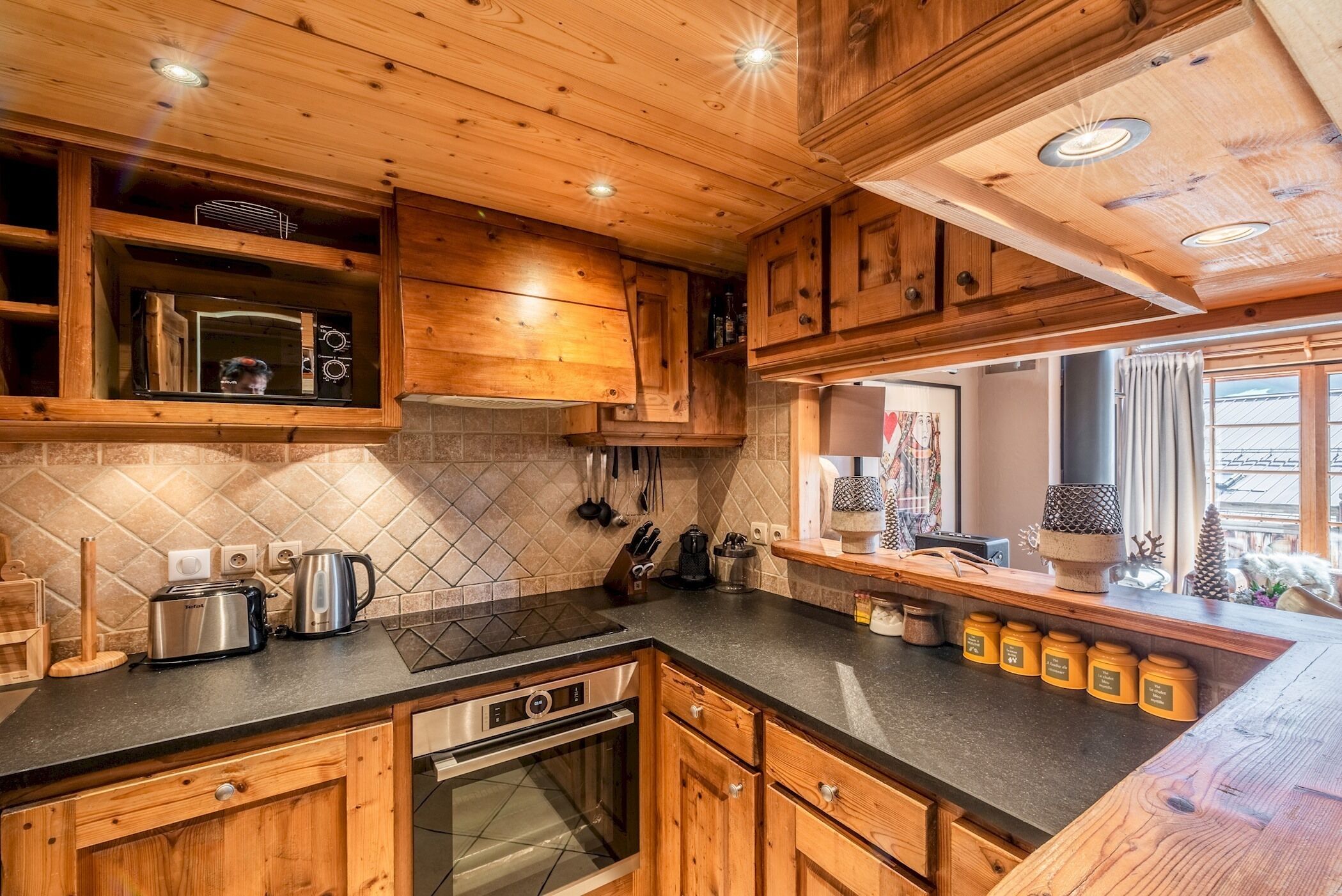 A kitchen with wooden cabinets, a built-in microwave, a stove, and a coffee maker.