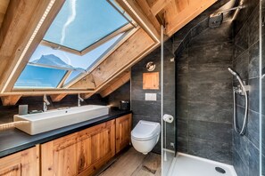 A modern bathroom with a skylight, a large sink, a toilet, and a shower. - GARAPA - Apartment in the heart of Morzine (Morzine)