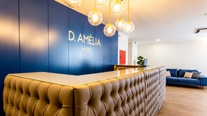 A reception desk with a blue wall and a sign reading "D. AMELIA HOTEL". - Dona Amélia Hotel by RIDAN Hotels (Ourem)