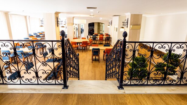 A hotel lobby with a staircase leading to a dining area. - Dona Amélia Hotel by RIDAN Hotels (Ourem)