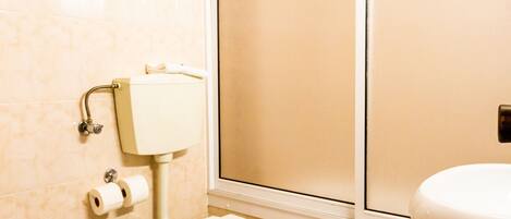 A bathroom with a toilet, bidet, and sink.
