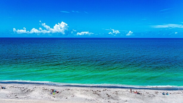 A beach with clear turquoise waters and a sandy shore. - 3's Company-"Villa Janet"- 1 Block from Gulf of Mexico, 300 feet to the Gulf (Englewood)
