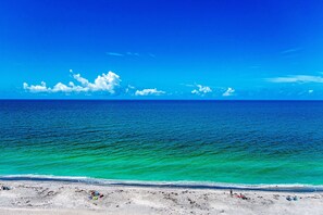 A beach with clear turquoise waters and a sandy shore.