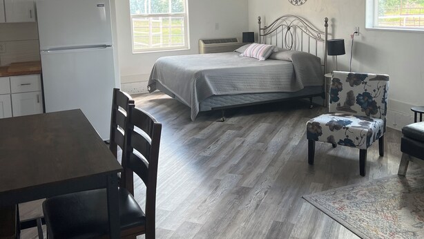 A bedroom with a bed, a ceiling fan, a window, and a nightstand. - Country Farmhouse (Monroe)