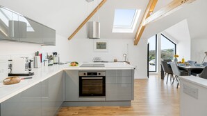 A modern kitchen with a built-in oven, a large island, and a skylight. - Perfect for a Cornish getaway, Cedar House is located just outside the hustle and bustle of St Agnes (St Agnes)