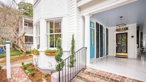 A white house with a front porch, a brick pathway, and a blue door. - The Honey Suite | Step Back in Time (Charleston)