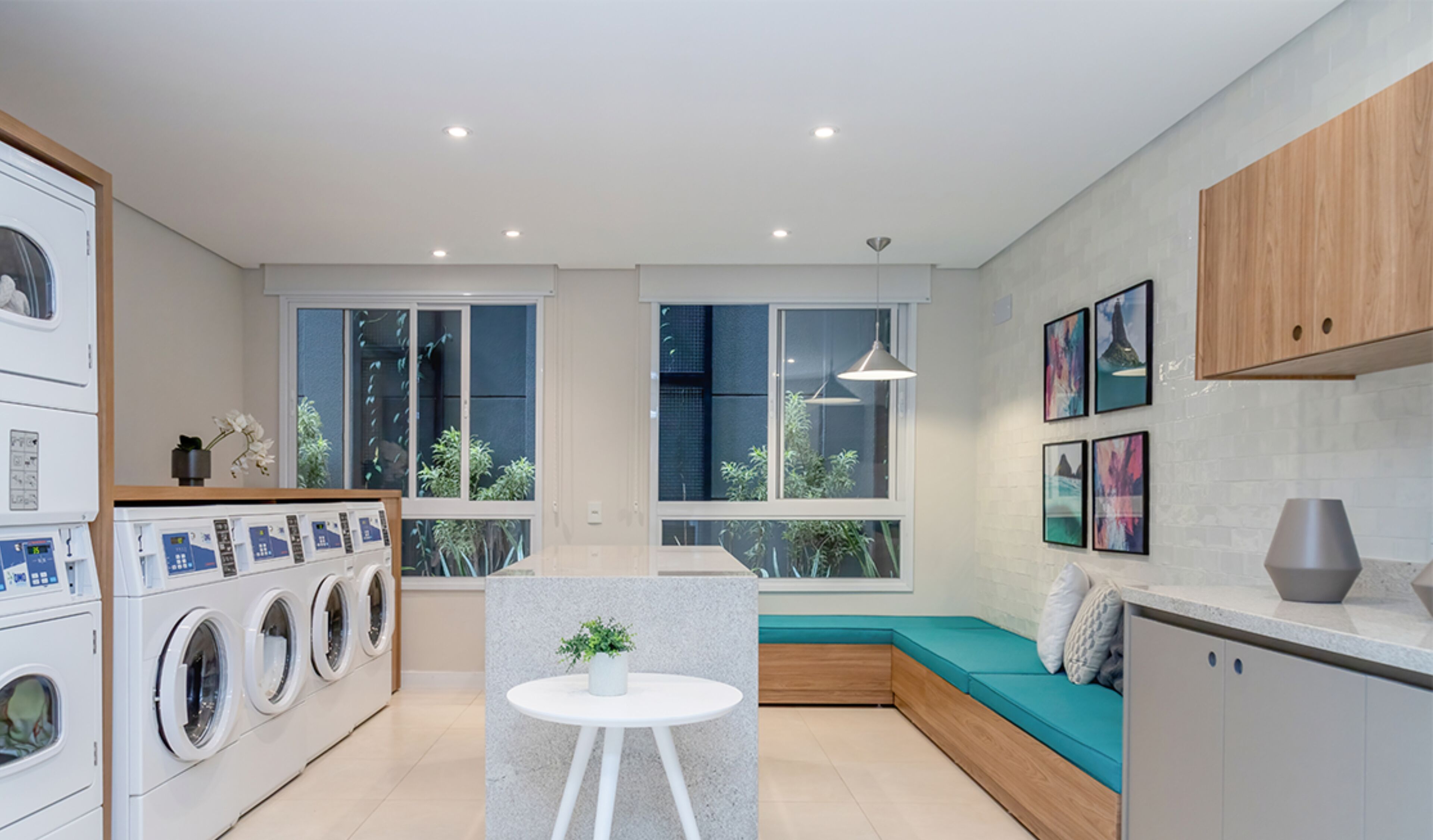 A modern kitchen with built-in appliances, a seating area with a view, and a small table with a plant.