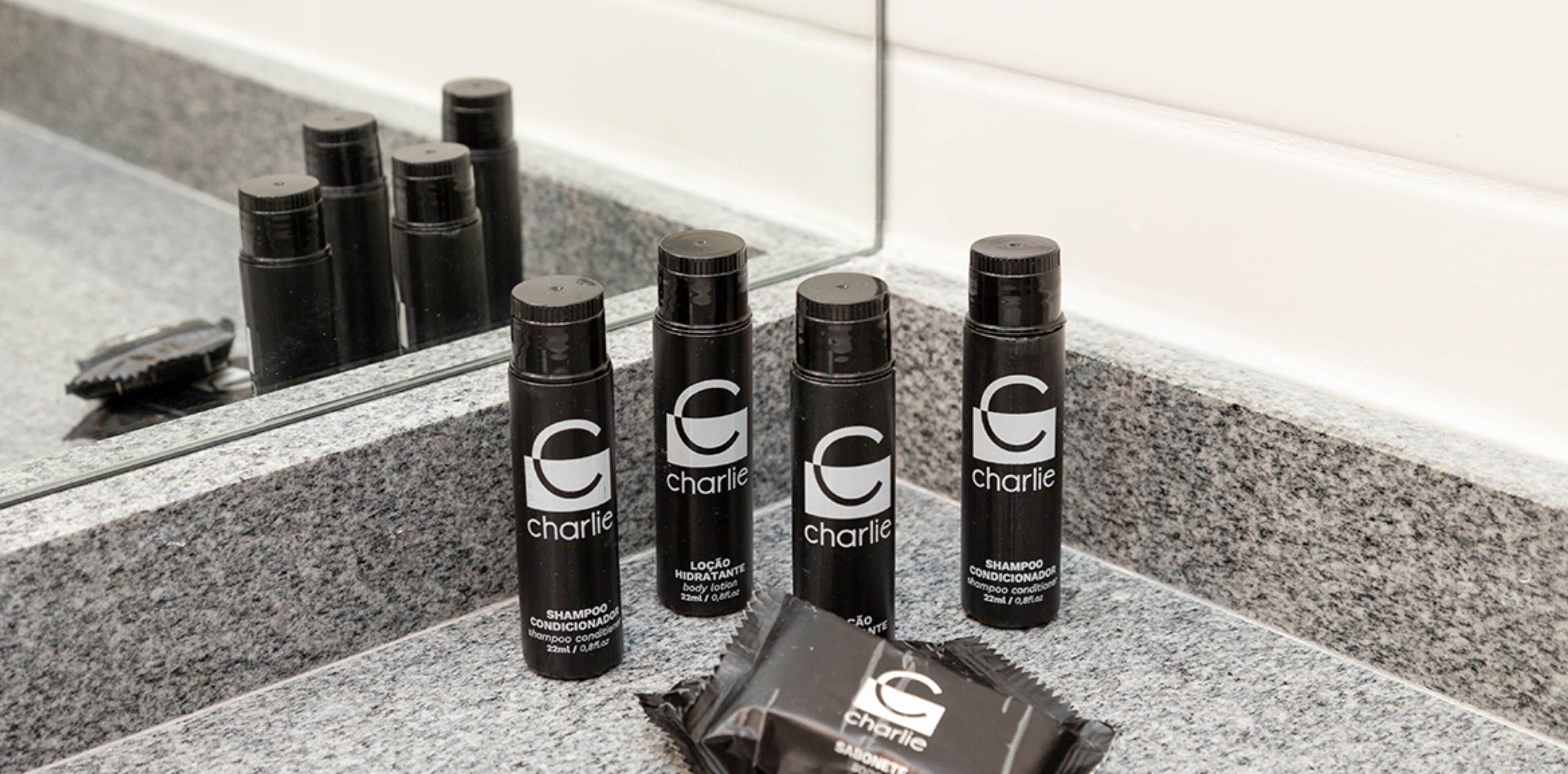A set of black bottles with white text and a logo, arranged on a stone surface.