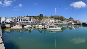 Un port où des bateaux sont amarrés, une jetée et des bâtiments le long du quai.