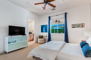 A bedroom with a bed, a TV on a cabinet, a ceiling fan, a window with curtains, and artwork on the wall. - Luxury Estate Home in Andreas Hills All En Suite, Saltwater Pool & Spa, Fire Pit (Palm Springs)