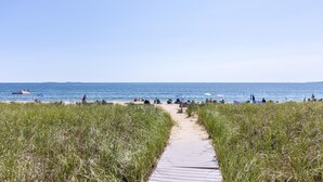 A beach path leading to the ocean with people and beach umbrellas. - Spectacular Oceanfront Property Offering Bold Panoramic Views of Saco Bay ! (Old Orchard Beach)