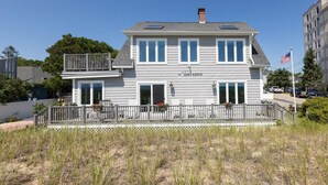 A two-story building with a balcony, a sign reading "GREY GOOSE," and a flag in the background. - Spectacular Oceanfront Property Offering Bold Panoramic Views of Saco Bay ! (Old Orchard Beach)