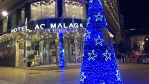 Un hôtel devant lequel trône un grand sapin de Noël bleu.
