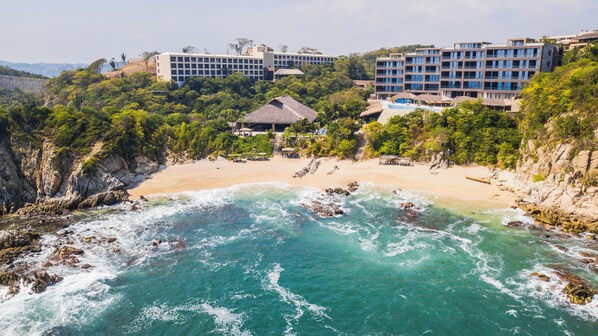 A coastal resort with a beach, ocean, and buildings. - Coral Blue Huatulco All Inclusive (Santa María Huatulco)