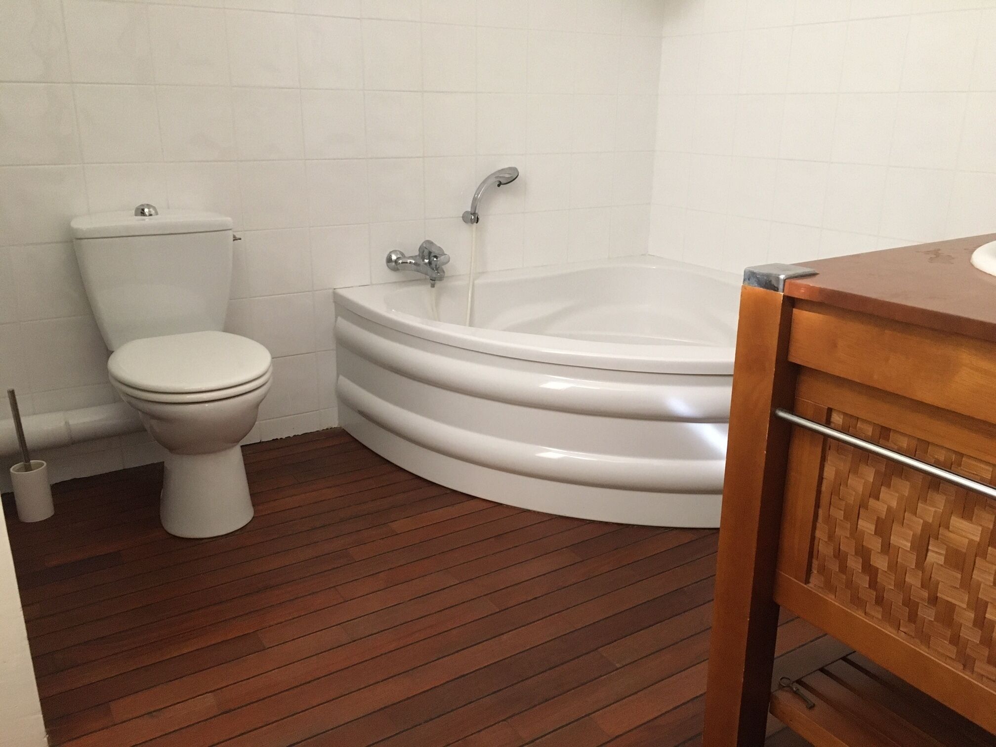 Un baño con inodoro, bañera y tocador de madera.