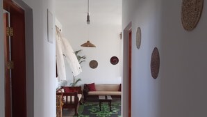 A hallway with a sofa, a dining table, and chairs. There are wall decorations and a hanging light fixture. - Lovely 4-bed Villa for Rent in Nungwi, Zanzibar (Nungwi)