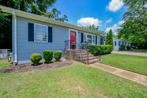 A single-story mobile home with a red front door, a small front porch, and a well-maintained lawn. - Wright Spot - Book now for football season! Close to Campus! (Tuscaloosa)
