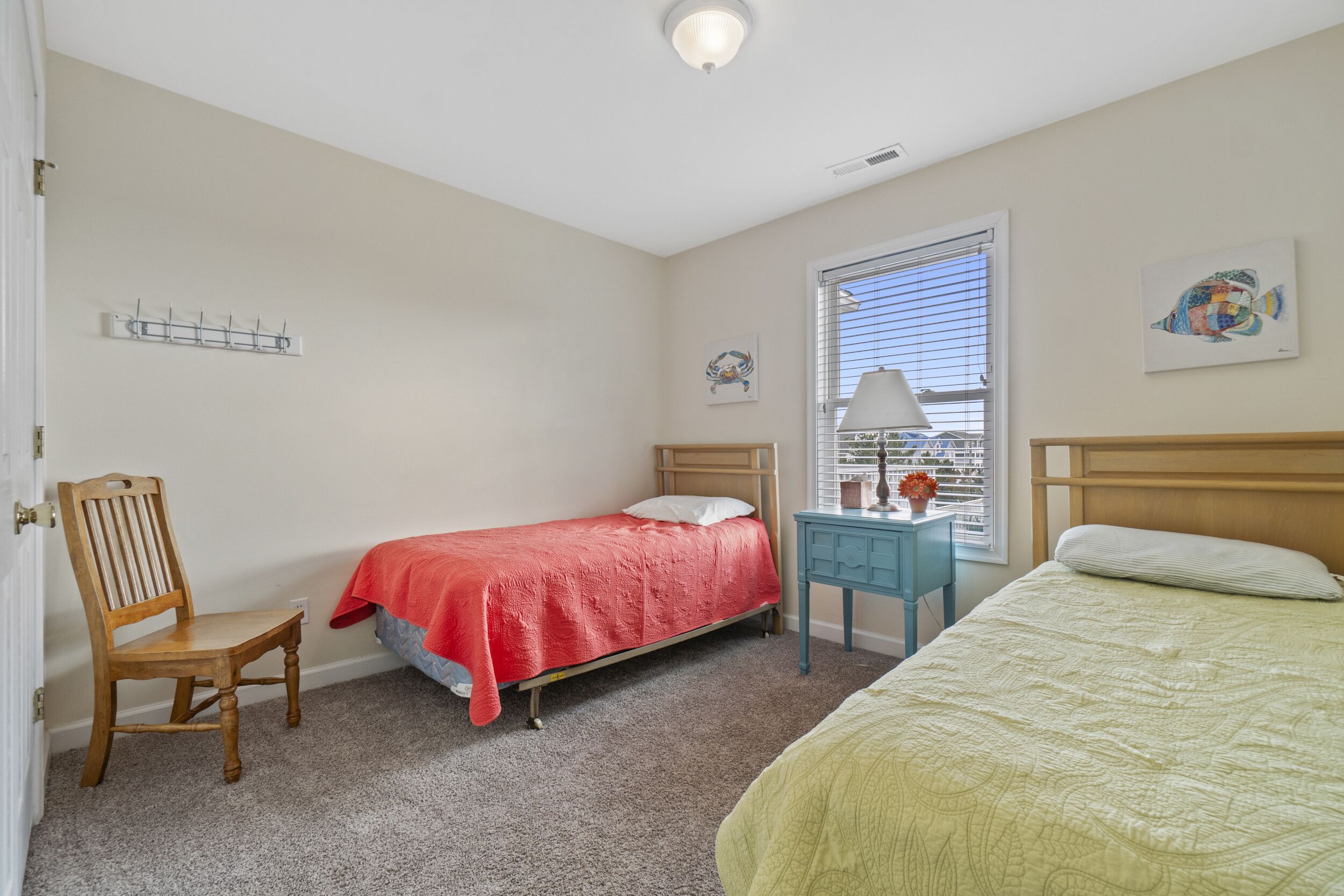 Un dormitorio con una cama individual, una silla, un escritorio y una ventana con persianas.