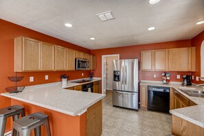 Una cocina con armarios de madera, electrodomésticos de acero inoxidable y encimera de granito.