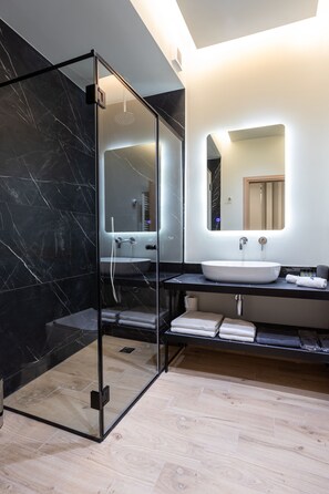Deluxe driepersoonskamer, uitzicht op de binnenplaats | Badkamer | Een douche, gratis toiletartikelen, een haardroger, badjassen