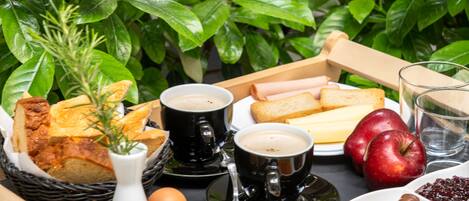 A tray with bread, eggs, coffee, and apples.