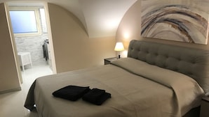 A bedroom with a large bed, a nightstand, a lamp, a painting on the wall, and a view of the outside. - Two steps from the sea and four from the historic center "Donizetti House" (Catania)