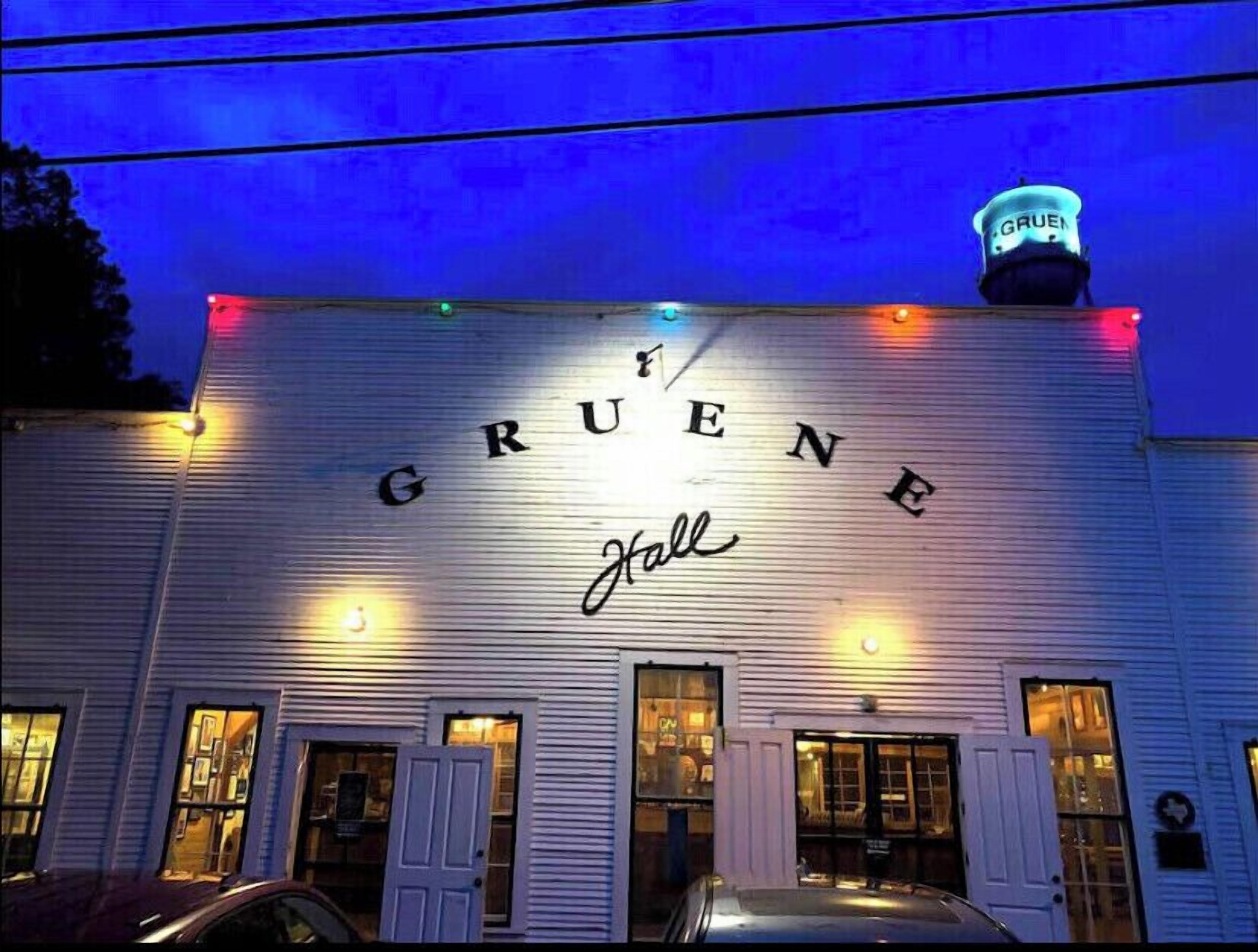 Un edificio con el nombre 'GRUENE Hall' iluminado en su fachada.
