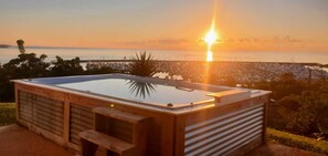 A wooden spa tub with a glass top, set against a sunset view over a marina. - Ocean View Sunset (Fajardo)