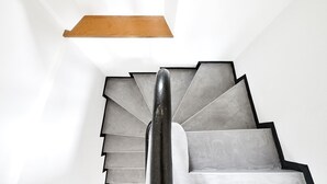 A modern staircase with a wooden ledge above and a metal handrail. - Ringelstein signal box (Büren)