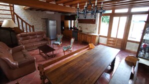 A spacious living area with a wooden ceiling, a large wooden dining table, leather sofas, and patterned chairs. - Wellness in Sologne La Frenaudiere spa (2 Villa la fronodiere. Gy-en-Sologne)