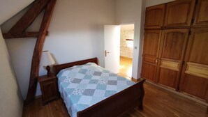 A bedroom with a wooden bed, a nightstand, and a wooden wardrobe. - Wellness in Sologne La Frenaudiere spa (2 Villa la fronodiere. Gy-en-Sologne)