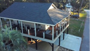 A two-story house with a covered porch and a deck. - Beautiful Beach Home -3 min walk to beach -with golf cart option (Myrtle Beach)