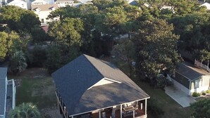 A residential area with houses, a large tree, and a view of the ocean. - Beautiful Beach Home -3 min walk to beach -with golf cart option (Myrtle Beach)
