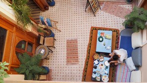 An outdoor seating area with a table set for a meal, surrounded by potted plants and a patterned floor. - RIADJENANADAM Marrakesh  (Marrakech)