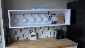 A kitchen with white cabinets, a wooden countertop, and a black refrigerator. - Feel at Home at this central and spacious 1 bedroom condo (Dallas)