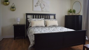 A bedroom with a bed, nightstand, dresser, and wall art. - Feel at Home at this central and spacious 1 bedroom condo (Dallas)