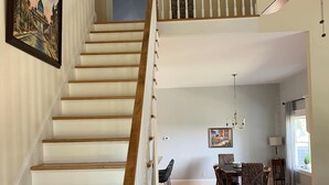 A staircase with wooden steps and white railings leading to a second floor.