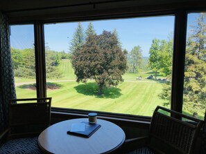 Ein Zimmer mit einem großen Fenster und Blick auf einen Golfplatz.