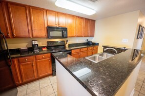 Enjoy cooking in this well-equipped kitchen with a microwave, oven, and sink.