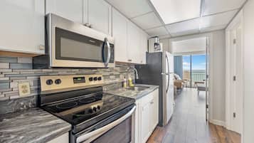 A modern kitchen with a built-in oven, microwave, and stainless steel appliances.