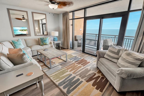 - Spacious living room with oceanfront views through floor to ceiling glass doors - Cozy sectional sofa and armchair with beach inspired decor for family gatherings - Relax and stream your favorite shows on the smart TV after a day at Myrtle Beach