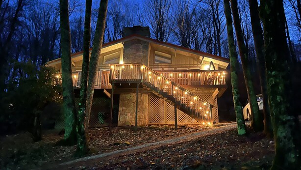 A stone building with a wooden staircase and balcony, surrounded by trees. - Spacious 3BR/3BA Cabin Only 0.5 Miles From Slopes! (Beech Mountain)