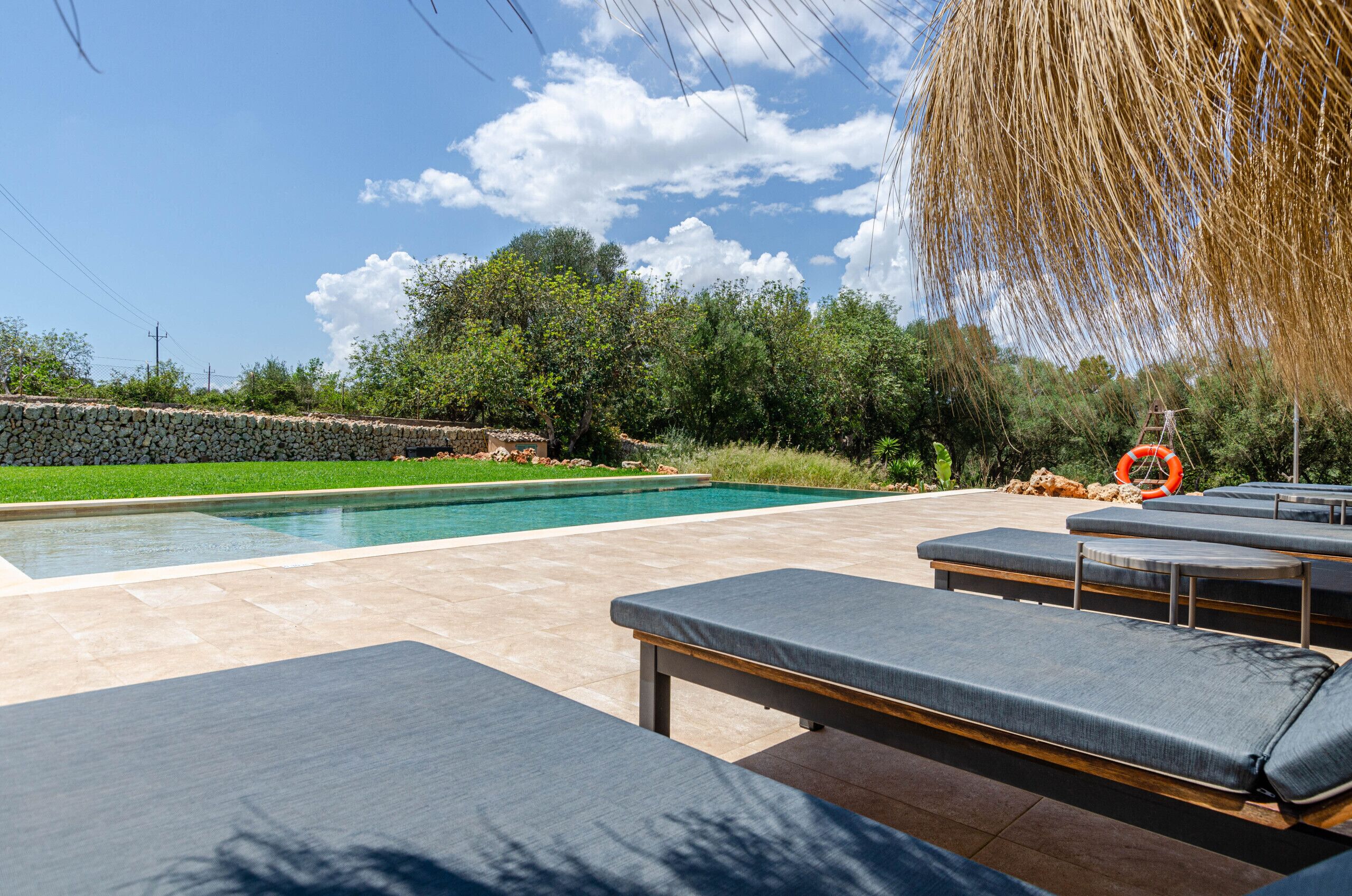 Une piscine avec des chaises longues et un cercle de sauvetage.