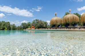 A clear pool with lounge chairs and thatched umbrellas, surrounded by greenery. - Cal Tio 2  YourHouse, quiet rural home with shared pool (Costitx)
