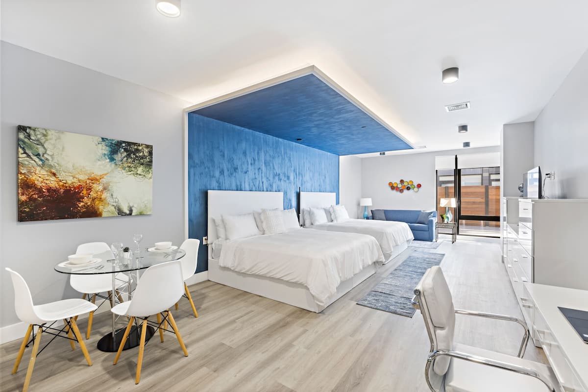 Une chambre d’hôtel moderne dotée d’un grand lit, d’une table à manger et d’un coin salon.