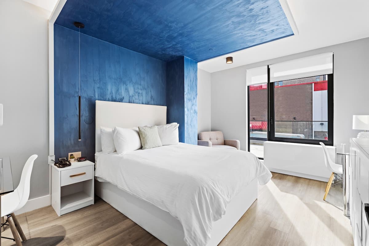 Une chambre à coucher moderne avec un grand lit, un bureau et une chaise.