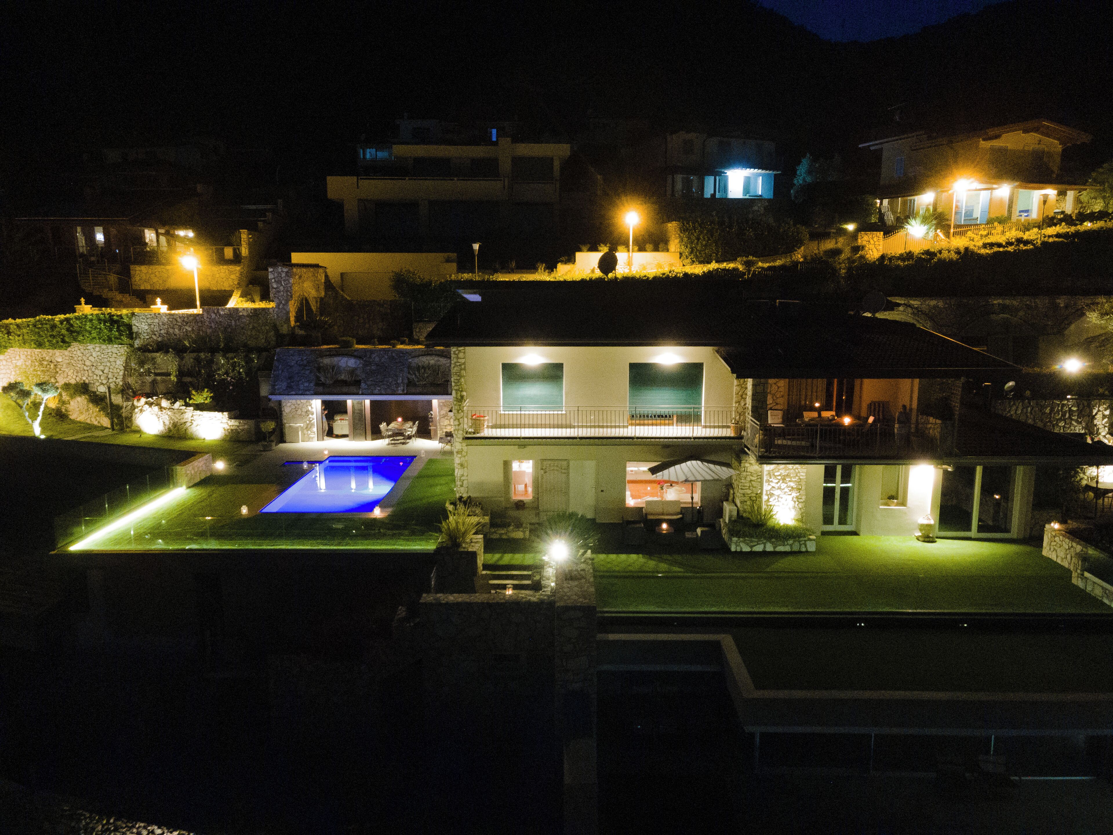 Une maison moderne dotée d’une piscine, d’un patio couvert et d’un mur en pierre.